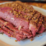 Sliced Instant Pot corned beef topped with mustard seeds and spices