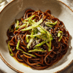 Black Bean Noodles Vegetarian Recipe That’s Better Than Takeout 3 Black bean noodles vegetarian recipe in ceramic bowl topped with cucumbers