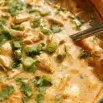 Bowl of delicious white chili chicken topped with cilantro and cheese