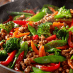 Ground turkey stir fry with colorful vegetables in a skillet coated in a glossy savory sauce.
